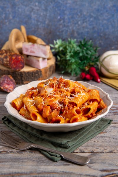 Rigatoni alla silana conditi con sugo di pomodoro e salsiccia, spolverati di formaggio grattugiato