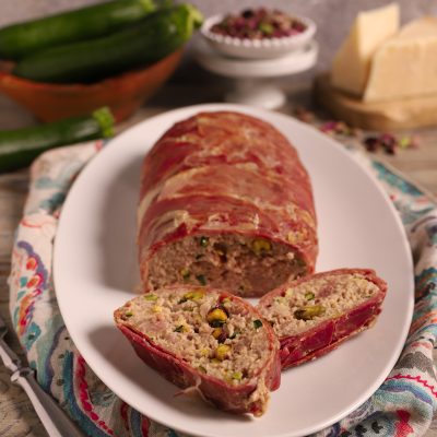 Rotolo di prosciutto di Federico Fellini affettato, con ripieno di carne e pistacchi in vista