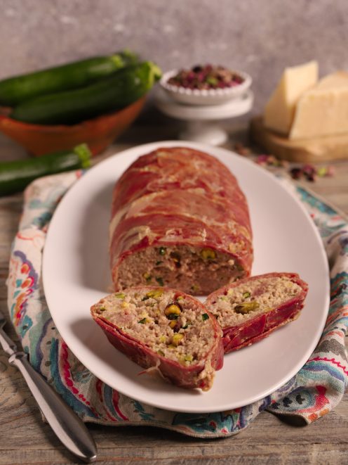 Rotolo di prosciutto di Federico Fellini affettato, con ripieno di carne e pistacchi in vista