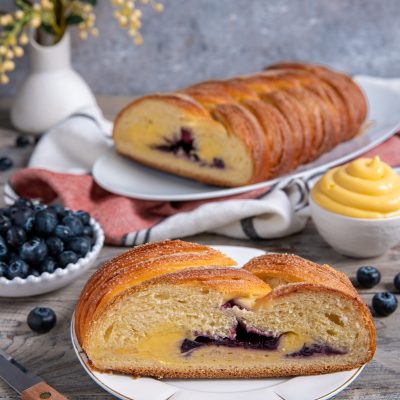 Treccia mochena a fette con cuore di crema pasticcera e mirtilli in evidenza