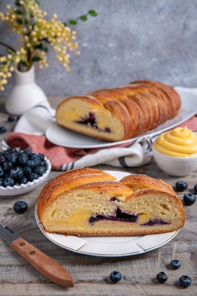 Treccia mochena a fette con cuore di crema pasticcera e mirtilli in evidenza