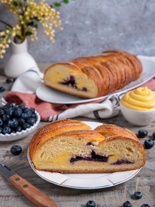 Treccia mochena a fette con cuore di crema pasticcera e mirtilli in evidenza