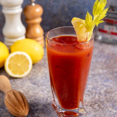 Bloody Mary servito con ghiaccio, guarnito con sedano fresco e uno spicchio di limone