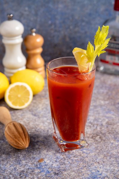 Bloody Mary servito con ghiaccio, guarnito con sedano fresco e uno spicchio di limone