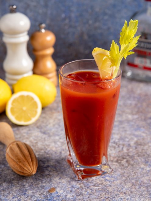 Bloody Mary servito con ghiaccio, guarnito con sedano fresco e uno spicchio di limone