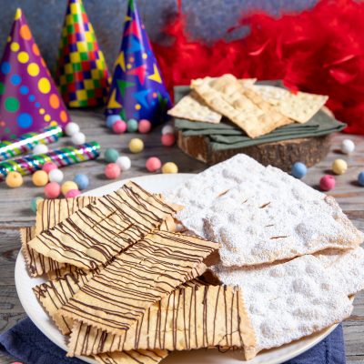Chiacchiere al forno con zucchero a velo e filetti di cioccolato fondente