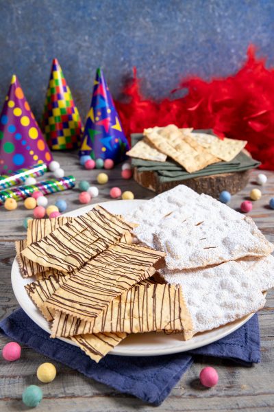 Chiacchiere al forno con zucchero a velo e filetti di cioccolato fondente
