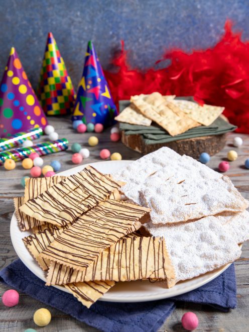 Chiacchiere al forno con zucchero a velo e filetti di cioccolato fondente