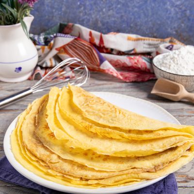 Crepes senza uova piegate a metà e impilate, dorate e sottili