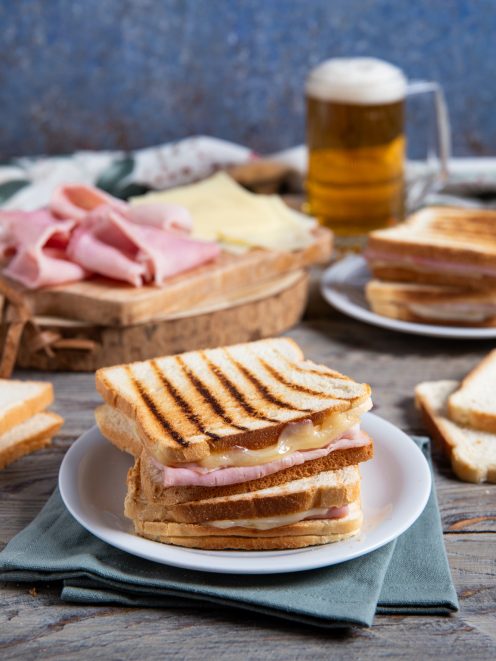 Toast alla piastra con prosciutto cotto e formaggio filante, servito a metà