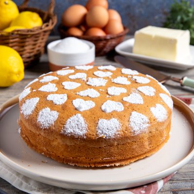 Torta semplice dorata decorata con zucchero a velo a forma di cuori