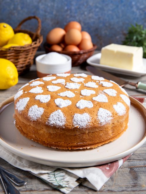 Torta semplice dorata decorata con zucchero a velo a forma di cuori