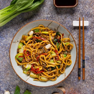 Yaki udon saltati con carne macinata, bok choy, peperoni rossi e semi di sesamo