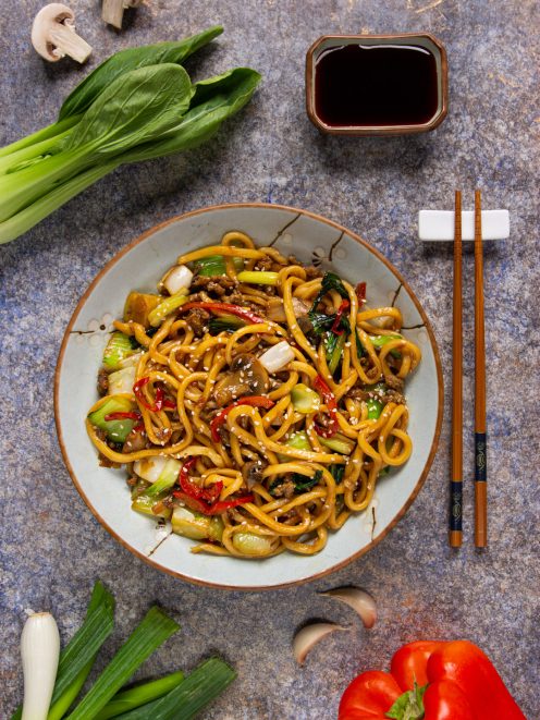 Yaki udon saltati con carne macinata, bok choy, peperoni rossi e semi di sesamo