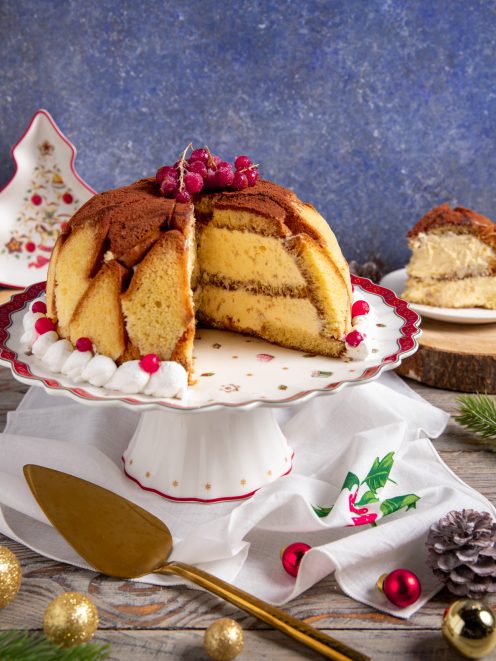 Zuccotto di pandoro a cupola tagliato a spicchi, farcito di crema e spolverato di cacao con ribes rosso