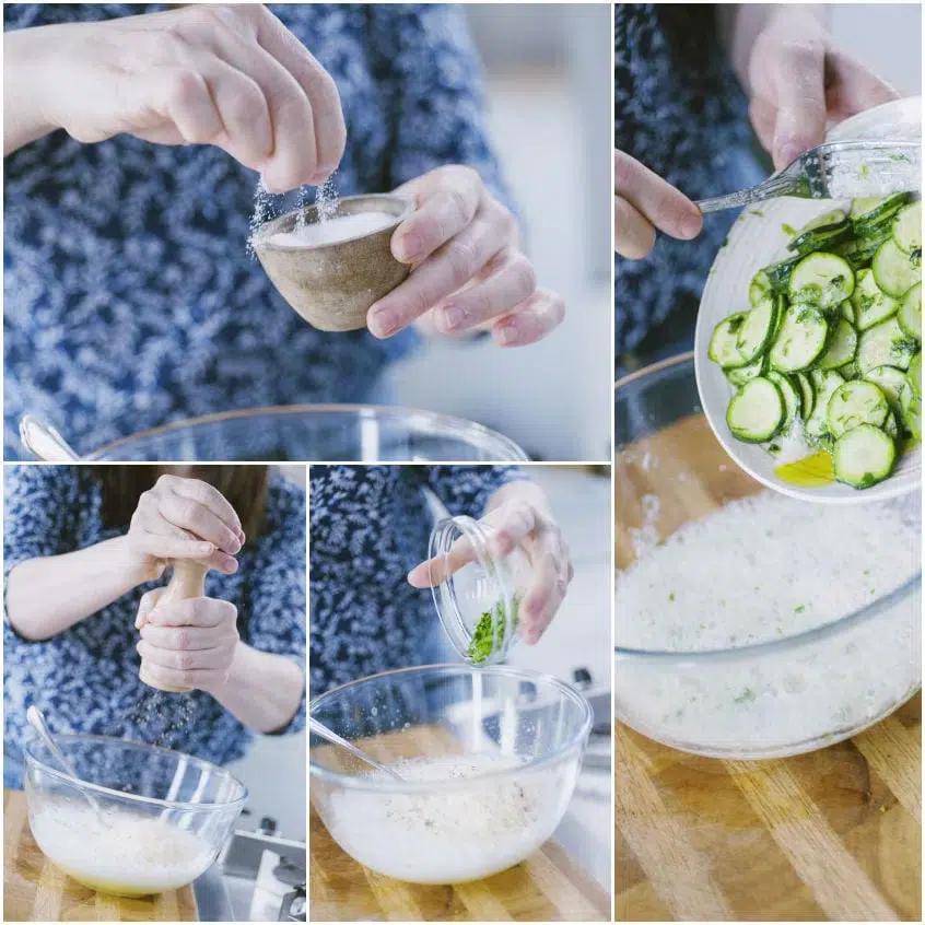 Mani che aggiungono prezzemolo e condimenti agli albumi montati con zucchine a rondelle