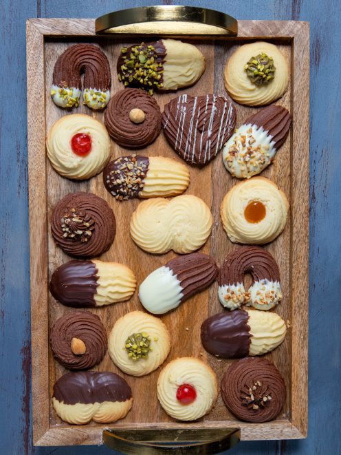 Biscotti di frolla montata assortiti con cioccolato fondente, bianco, pistacchi e ciliegine
