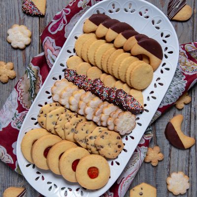 Biscotti di pasta frolla assortiti con glassa al cioccolato, confettini colorati e marmellata