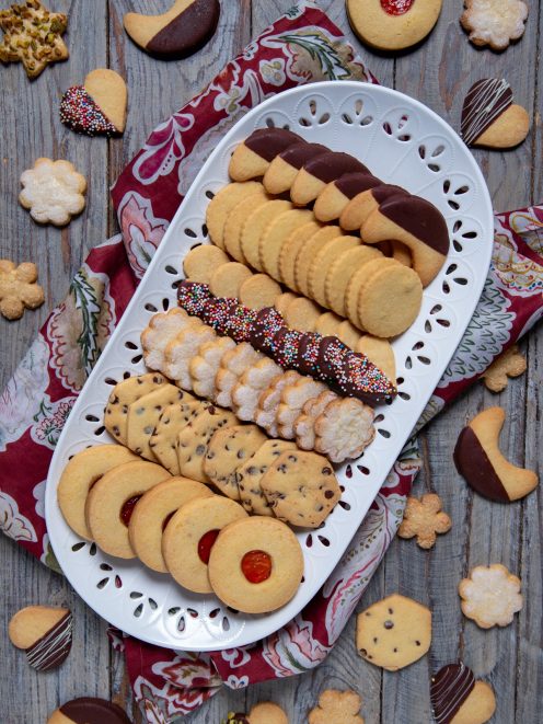 Biscotti di pasta frolla assortiti con glassa al cioccolato, confettini colorati e marmellata