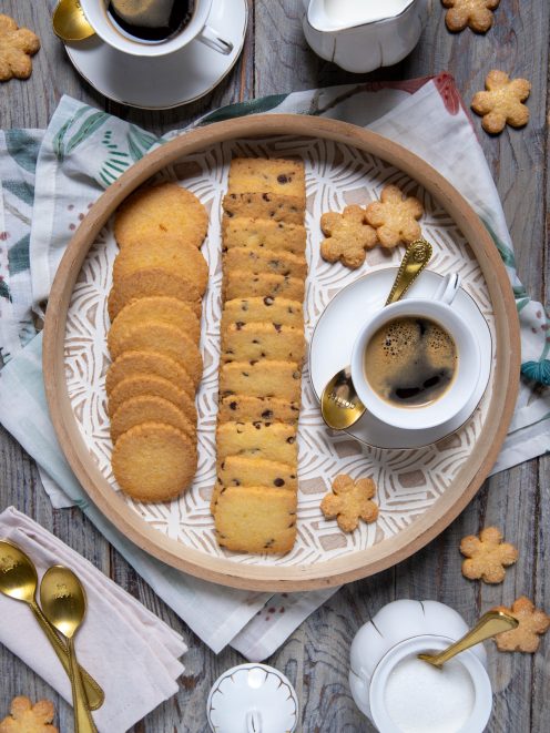 Biscotti senza glutine rotondi e con gocce di cioccolato serviti con una tazzina di caffè espresso