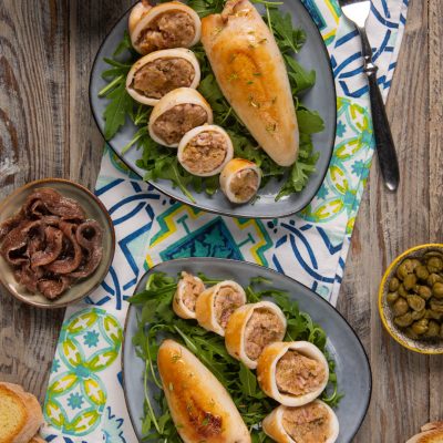 Calamari ripieni affettati su letto di rucola, con il ripieno di carne ben visibile