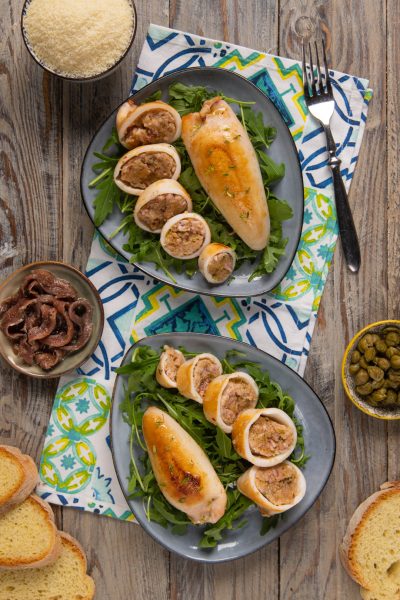 Calamari ripieni affettati su letto di rucola, con il ripieno di carne ben visibile