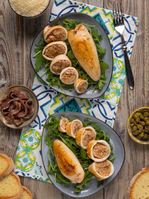 Calamari ripieni affettati su letto di rucola, con il ripieno di carne ben visibile