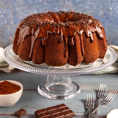 Ciambella al cioccolato con glassa colante e scaglie di cioccolato fondente sulla sommità