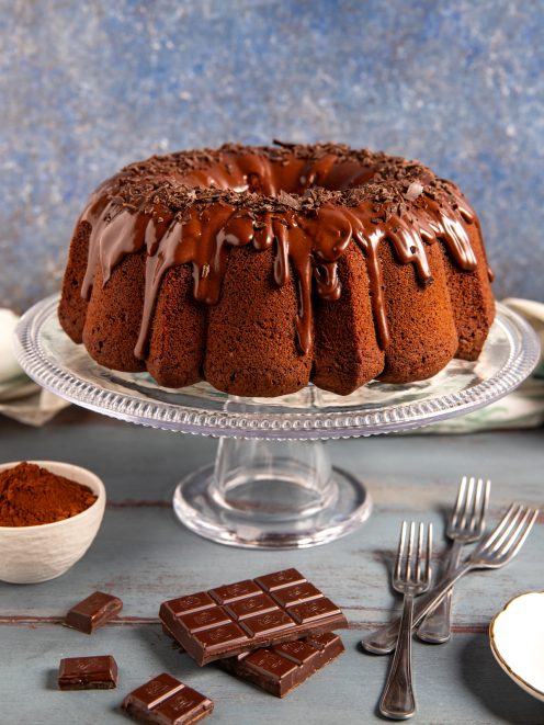 Ciambella al cioccolato con glassa colante e scaglie di cioccolato fondente sulla sommità