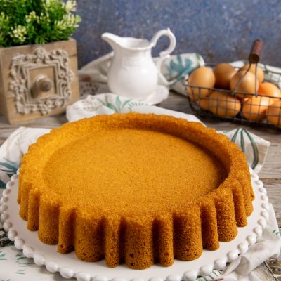 Crostata morbida appena sfornata con bordi scanalati e superficie dorata e compatta