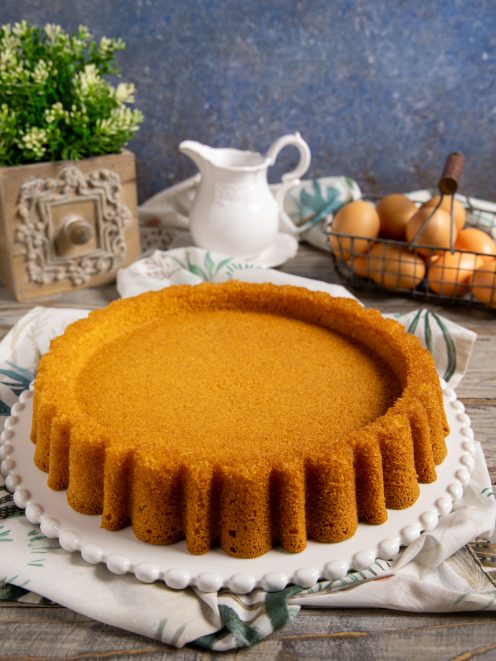 Crostata morbida appena sfornata con bordi scanalati e superficie dorata e compatta