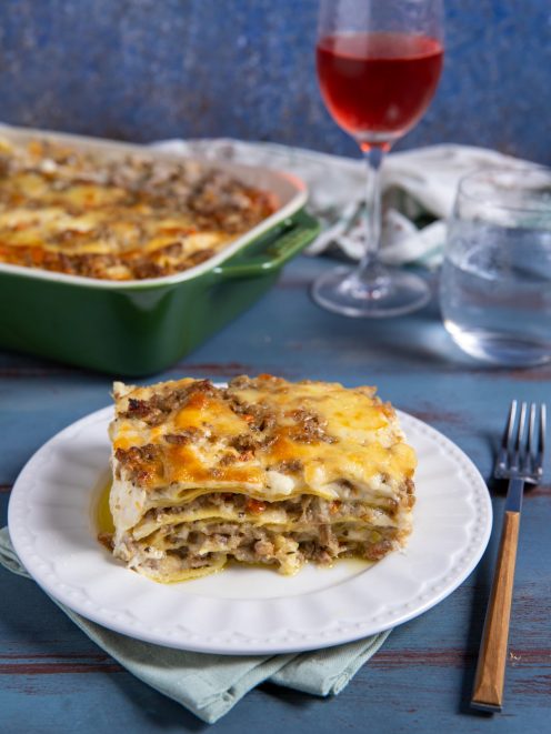 Lasagna bianca con strati di ragù e besciamella gratinata, servita a fetta
