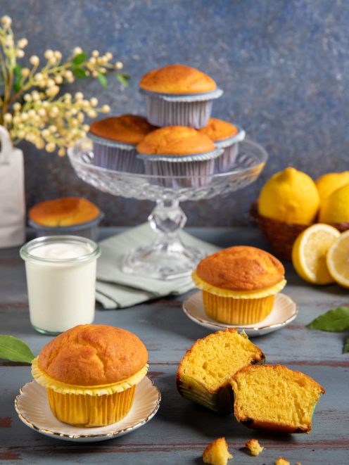 Muffin allo yogurt con cupola dorata, uno spezzato mostra la mollica soffice e compatta