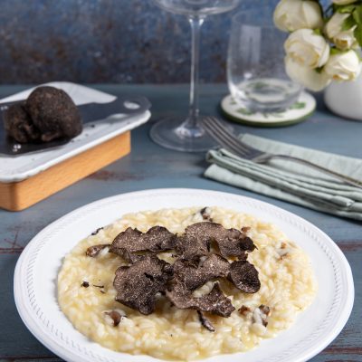 Risotto al tartufo mantecato e cremoso, coperto da generose lamelle di tartufo nero