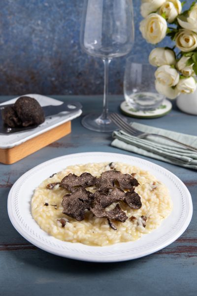 Risotto al tartufo mantecato e cremoso, coperto da generose lamelle di tartufo nero