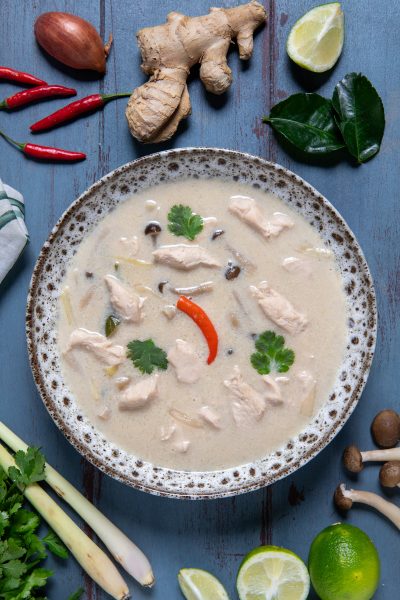 Tom kha gai con pollo, funghi e peperoncino in brodo cremoso di cocco, guarnito con coriandolo fresco