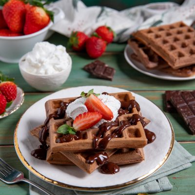 Waffle al cacao con salsa al cioccolato, panna montata e fragole fresche