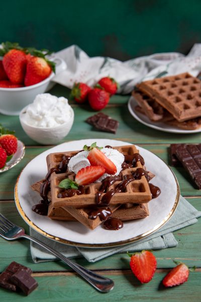 Waffle al cacao con salsa al cioccolato, panna montata e fragole fresche