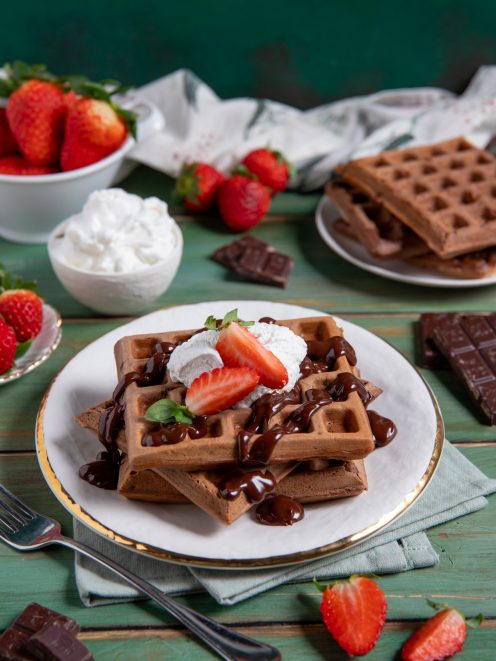 Waffle al cacao con salsa al cioccolato, panna montata e fragole fresche