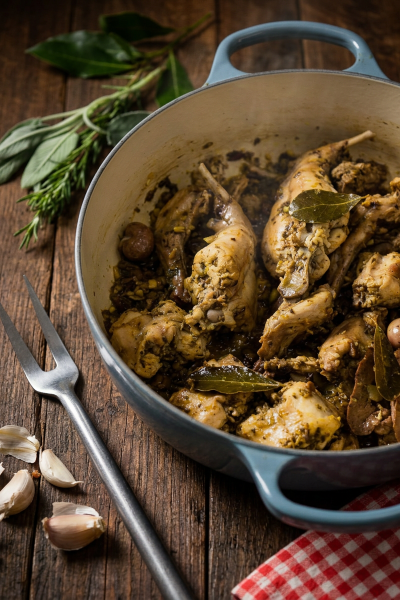 Coniglio alla ligure con olive, foglie di alloro e salsa alle erbe aromatiche