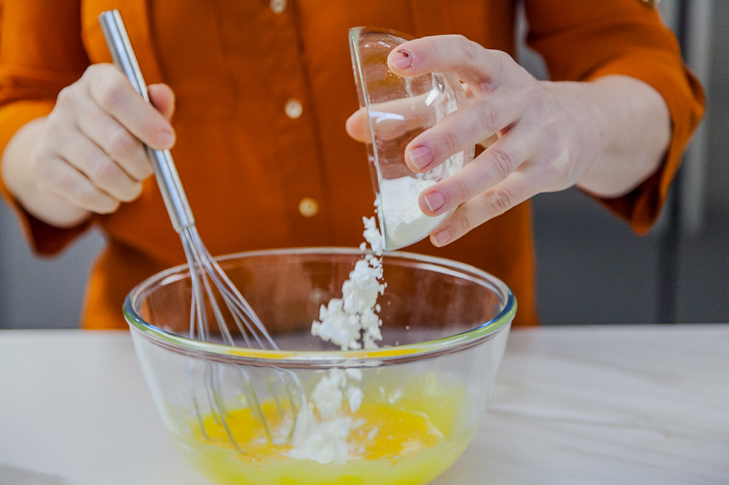 Amido di mais versato in una ciotola con tuorli mentre si prepara la crema catalana