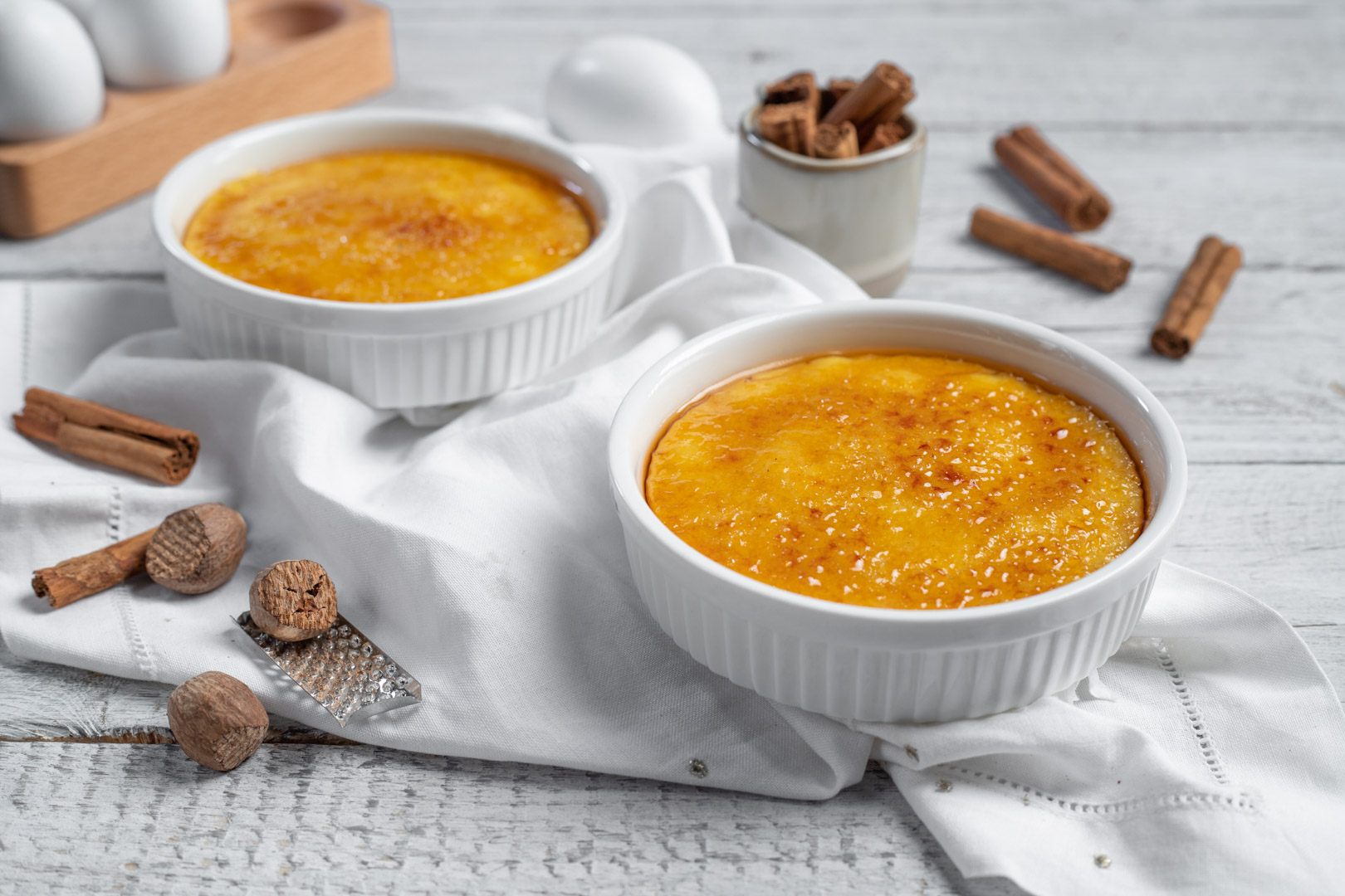Due cocottine di crema catalana con superficie caramellata dorata e croccante appena gratinata
