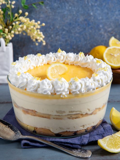 Tiramisù al limone a strati con crema, curd di limone, panna montata e fettine di limone