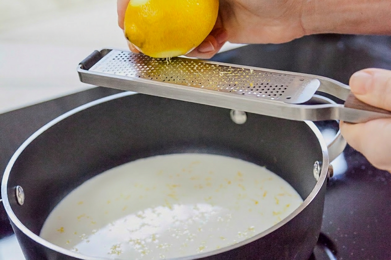 Scorza di limone grattugiata direttamente nel latte caldo in padella