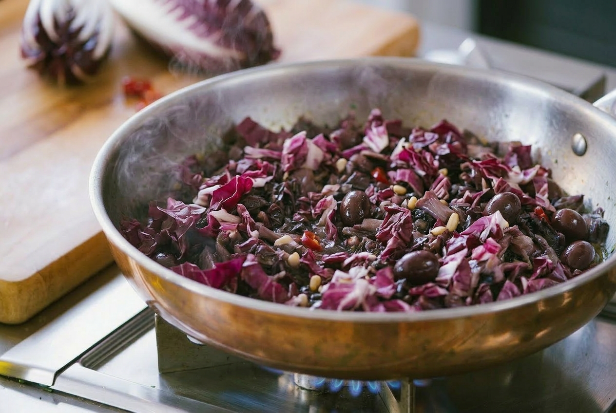 Radicchio saltato in padella con olive e pinoli su fiamma viva