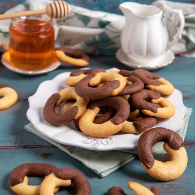 Biscotti abbracci bicolore con impasto chiaro e al cacao, serviti in abbondanza