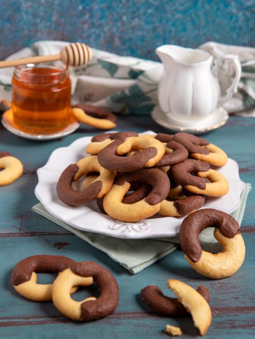 Biscotti abbracci bicolore con impasto chiaro e al cacao, serviti in abbondanza