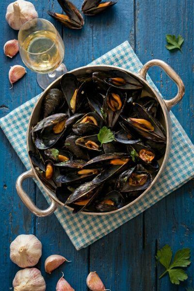 Cozze alla marinara aperte in padella, guarnite con prezzemolo fresco