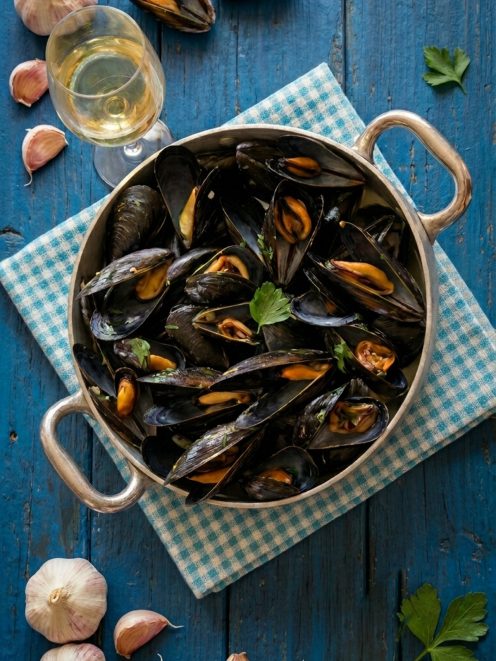 Cozze alla marinara aperte in padella, guarnite con prezzemolo fresco