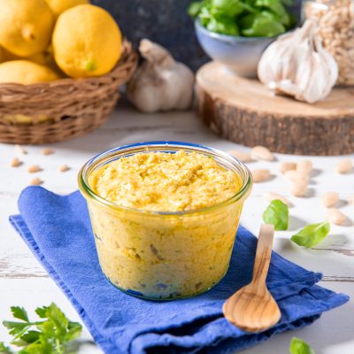 Pesto di limoni in vasetto con pinoli, aglio e foglie di basilico intorno